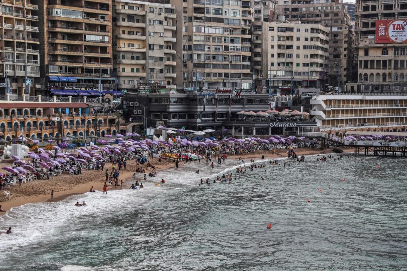 مصطافون يستمتعون بالشمس والبحر على أحد شواطئ الإسكندرية 